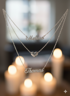 Two silver name necklaces with 'Melissa' and 'Thomas' on a blurred background.